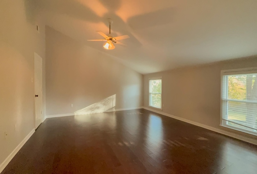 Unfurnished room featuring lofted ceiling, dark wood-style floors, and ceiling fan