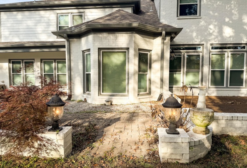 Property entrance featuring a patio area, brick siding, and roof with shingles