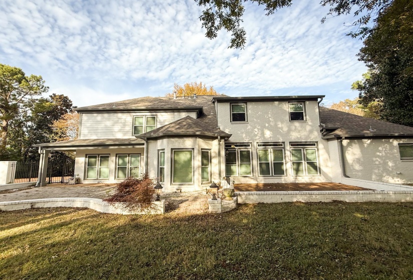 Back of house with a patio area, a shingled roof, and brick siding