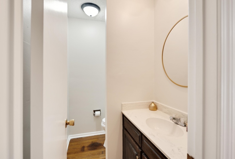 Half bathroom with dark wood finished floors and vanity