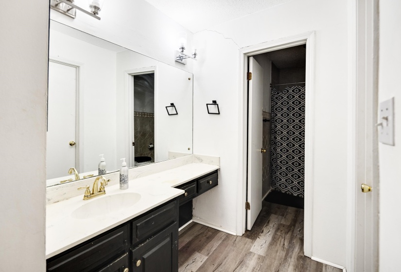 Full bath with vanity, a shower with curtain, and light wood-style flooring