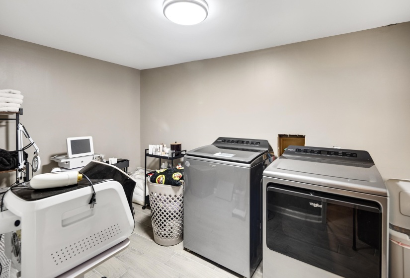 Laundry room featuring washing machine and dryer and light wood-type flooring