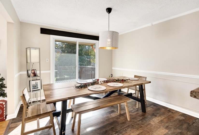 Dining space with wood finished floors, a textured ceiling, and crown molding