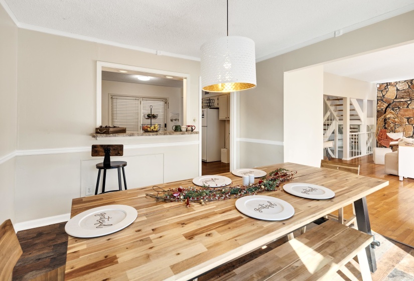 Dining room with crown molding, wood finished floors, stairway, and a textured ceiling