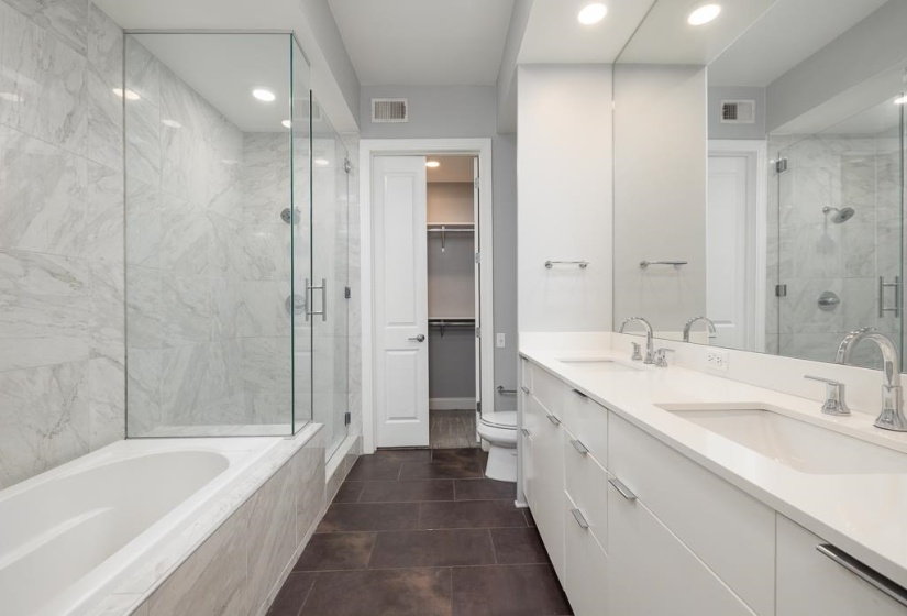 Full bathroom featuring double vanity, a stall shower, recessed lighting, a garden tub, and a walk in closet