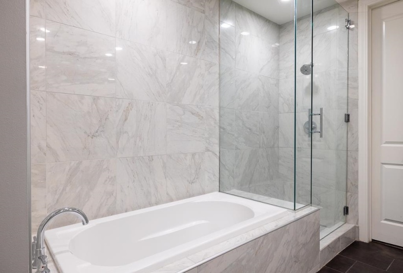 Bathroom with a bath and a marble finish shower