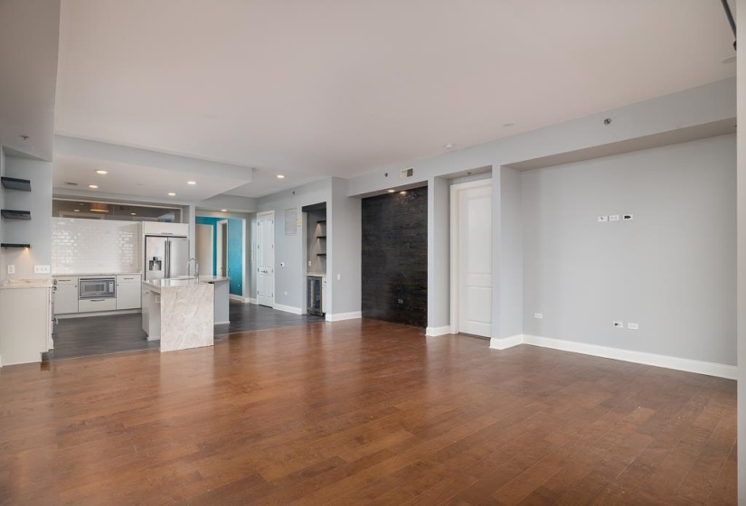 Unfurnished living room with dark wood-type flooring, recessed lighting, and wine cooler