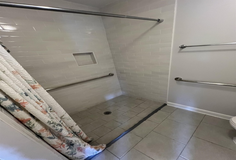 Full bath with a shower stall and light tile patterned flooring