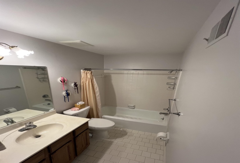 Full bathroom with shower / tub combo, light tile patterned floors, and vanity