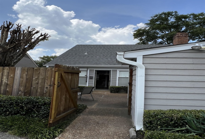 Property entrance with a shingled roof and a chimney