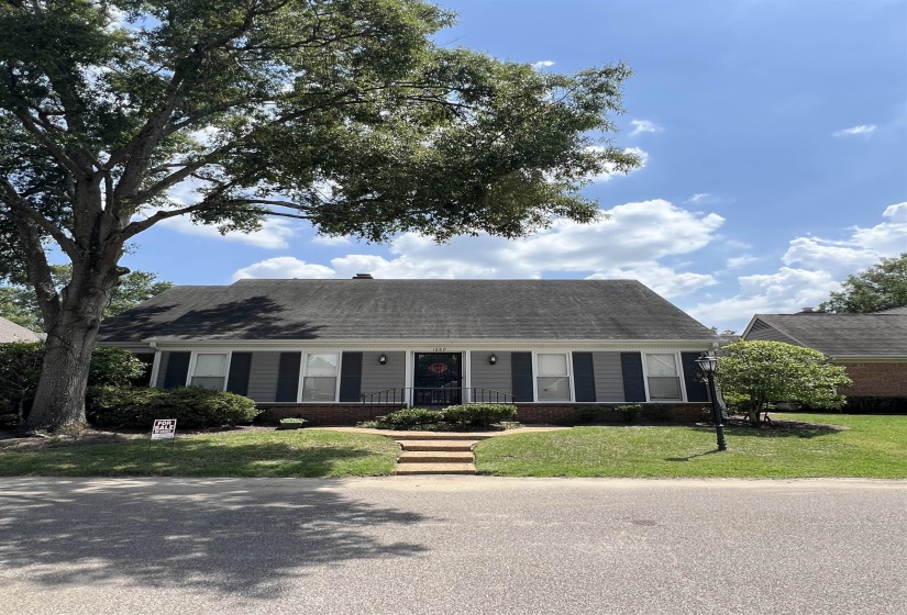 Single story home with covered porch, a front yard, brick siding, and a shingled roof