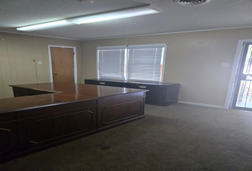Home office featuring a textured ceiling and dark carpet