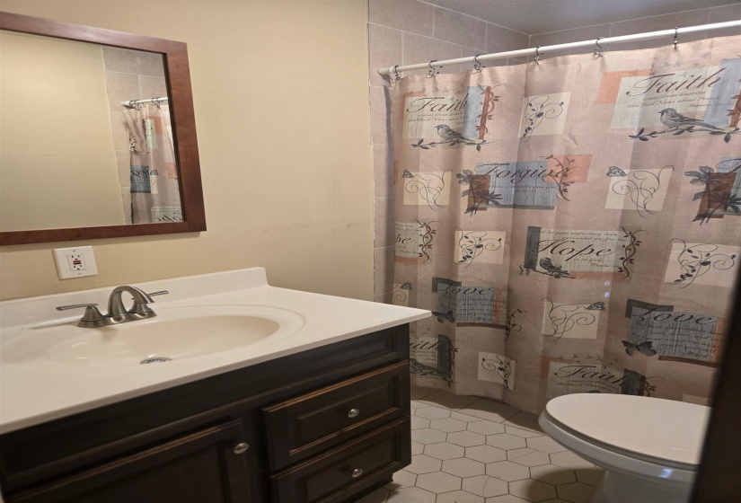 Full bathroom featuring vanity, light tile patterned floors, and a shower with curtain