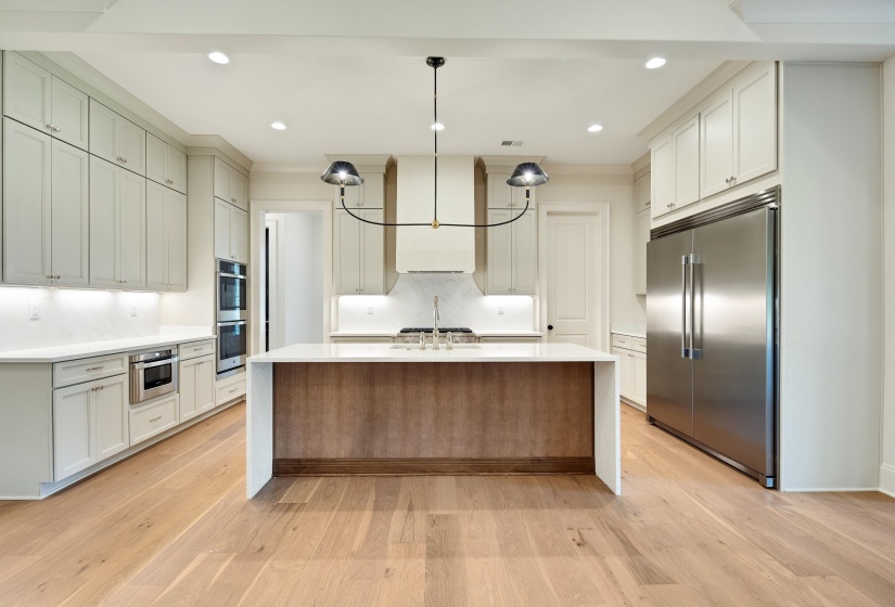 Kitchen featuring stainless steel appliances, light countertops, light wood-style flooring, backsplash, and recessed lighting