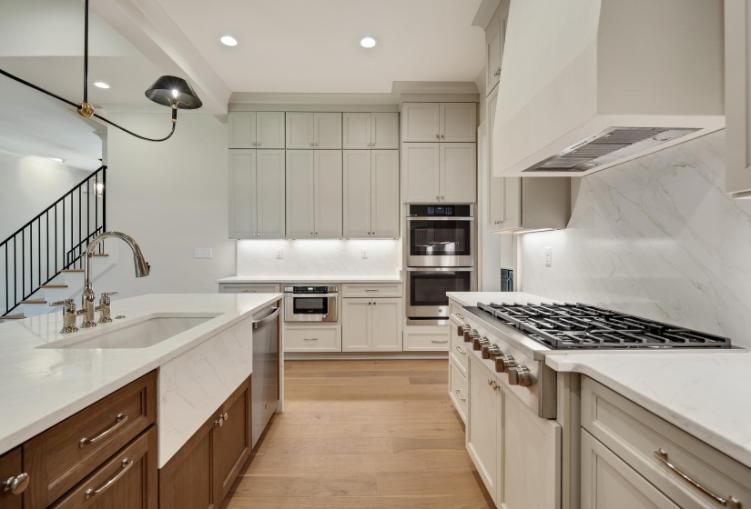 Kitchen with a sink, premium range hood, appliances with stainless steel finishes, tasteful backsplash, and recessed lighting