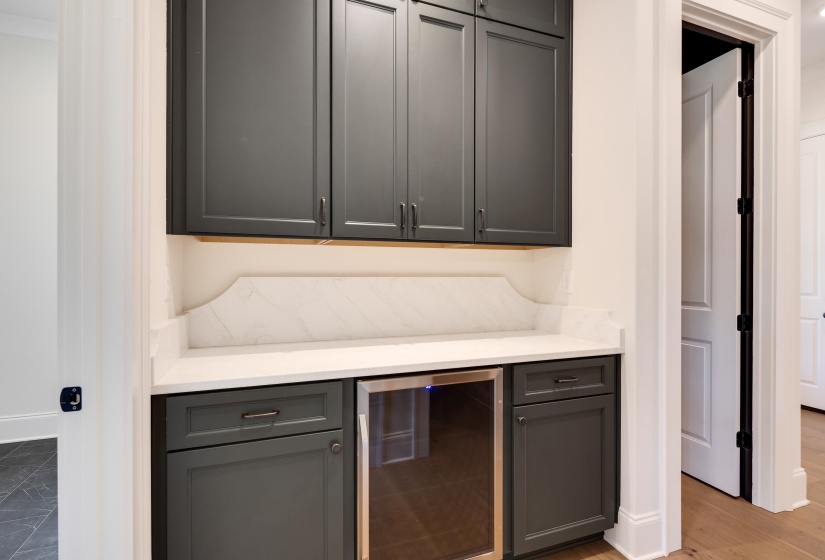 Bar featuring wine cooler and baseboards