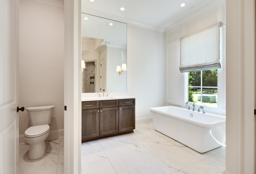 Bathroom featuring a freestanding bath, vanity, marble finish flooring, recessed lighting, and baseboards