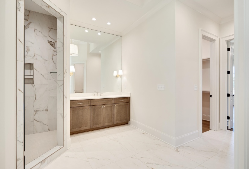Bathroom featuring marble look tile flooring, vanity, baseboards, a marble finish shower, and recessed lighting