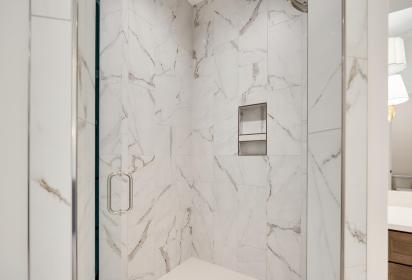 Full bath with a marble finish shower and vanity