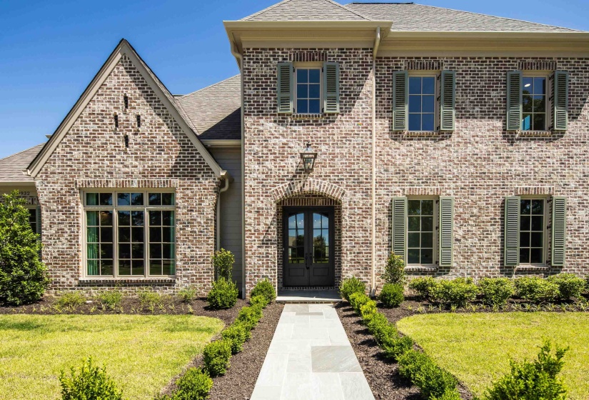 View of front of house with french doors, brick siding, a front lawn, and roof with shingles