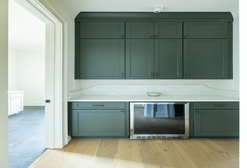 Bar featuring wine cooler and light wood-style floors