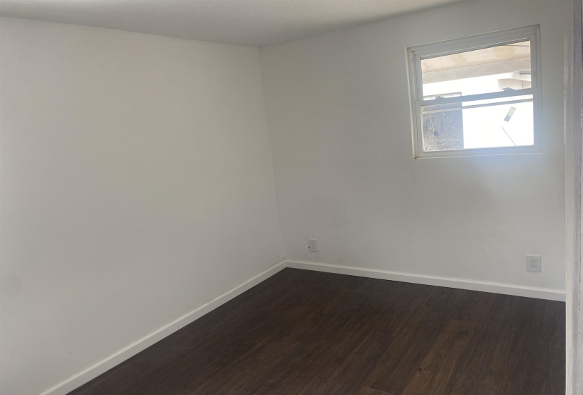 Bedroom with baseboards and dark wood finished floors