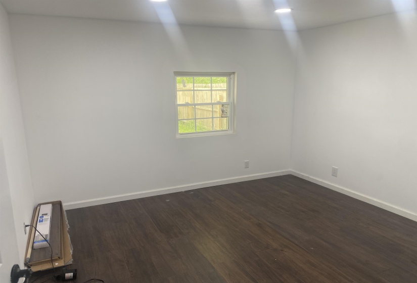 Bedroom with baseboards and dark wood-type flooring