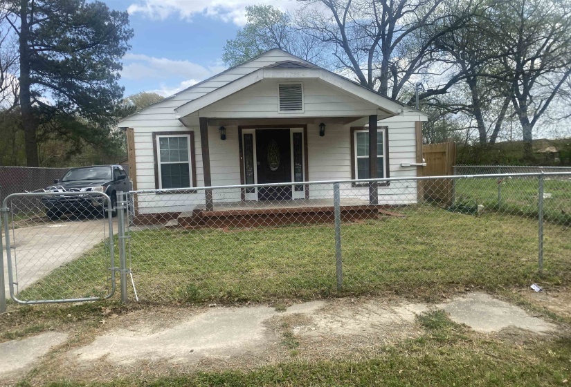 Bungalow-style house with covered porch, a fenced front yard, a gate, and a front lawn