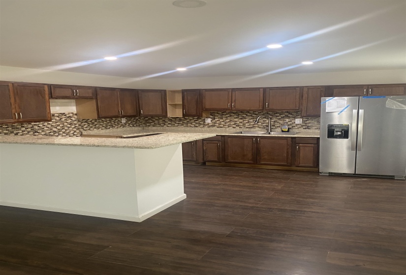 Kitchen with recessed lighting, stainless steel fridge, a sink, and tasteful backsplash