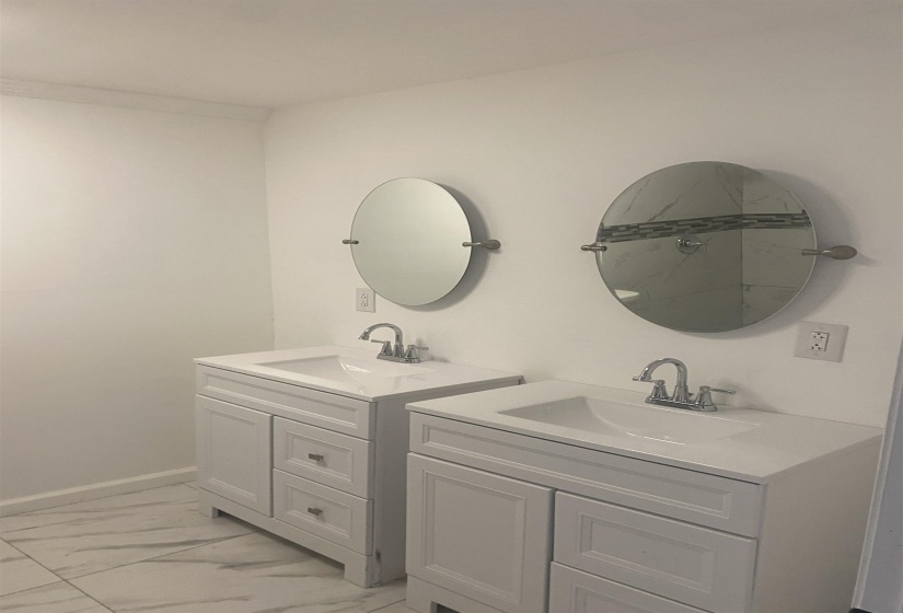 Full bath featuring a sink, two vanities, and marble finish floor