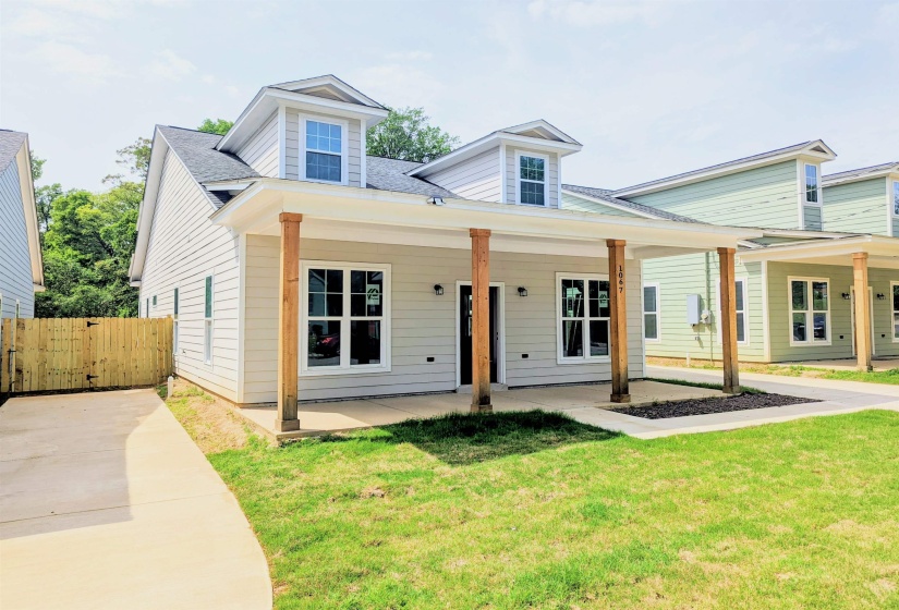 View of front of house featuring a gate, a front yard, covered porch, and a shingled roof