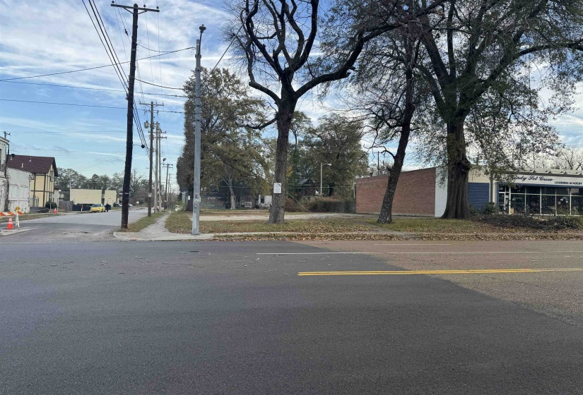 View of asphalt road with sidewalks, curbs, and street lighting