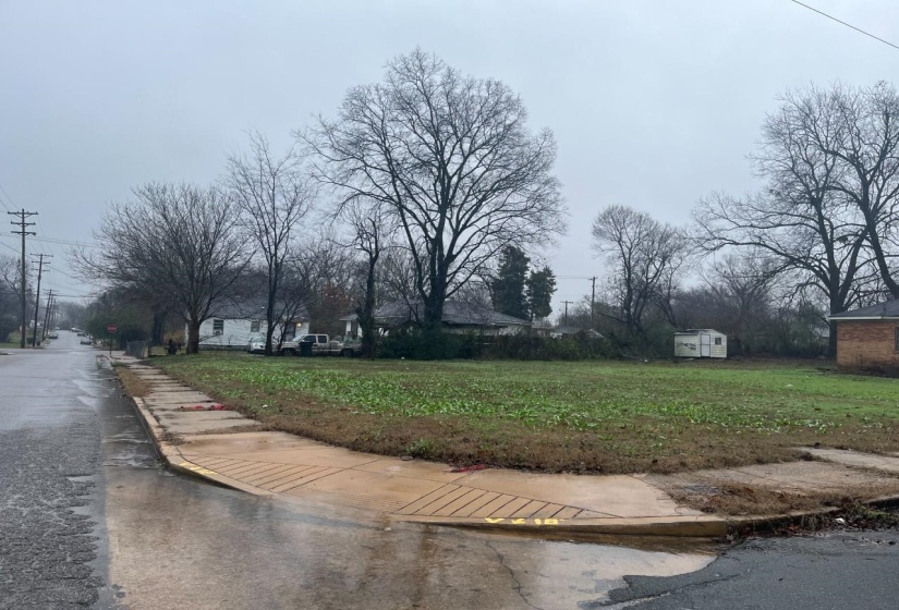 View of asphalt street featuring sidewalks and curbs