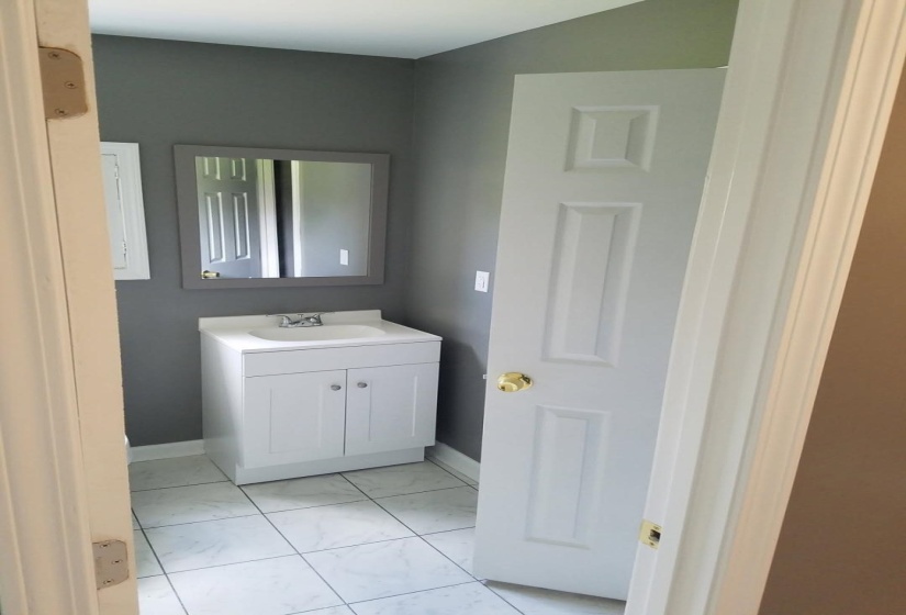 Bathroom featuring vanity and marble look tiles