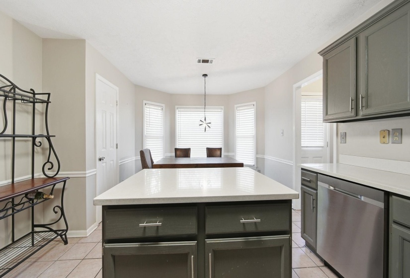 Kitchen featuring dishwasher, a center island, plenty of natural light, and light tile patterned floors