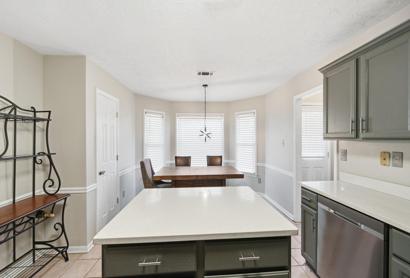 Kitchen featuring dishwasher, a kitchen island, pendant lighting, gray cabinets, and light tile patterned floors
