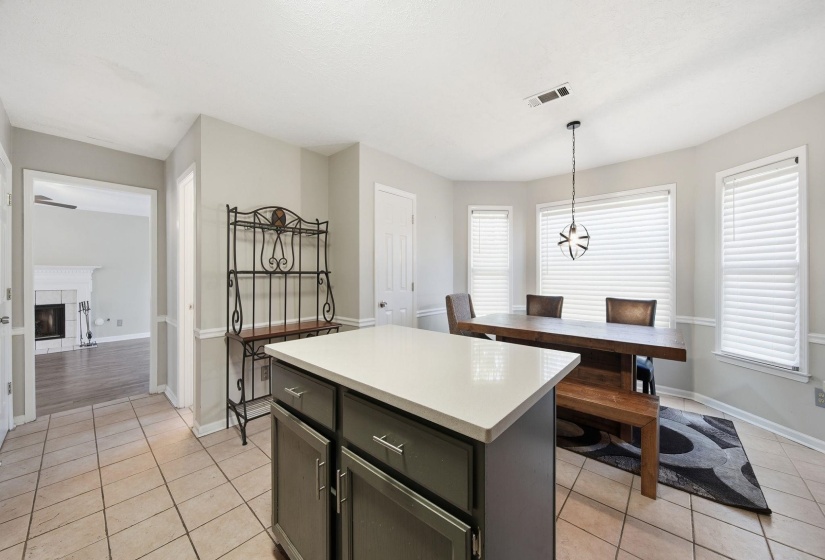 Kitchen featuring a center island, light countertops, a fireplace, and healthy amount of natural light