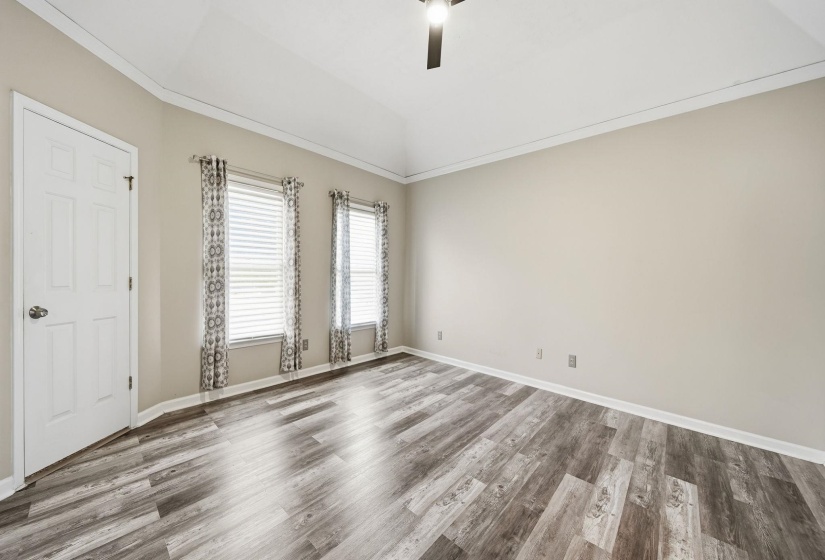 Unfurnished room featuring crown molding, lofted ceiling, wood finished floors, and ceiling fan
