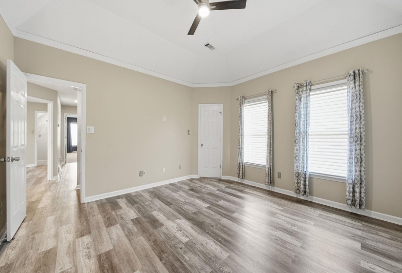 Spare room with a ceiling fan, light wood-type flooring, and ornamental molding