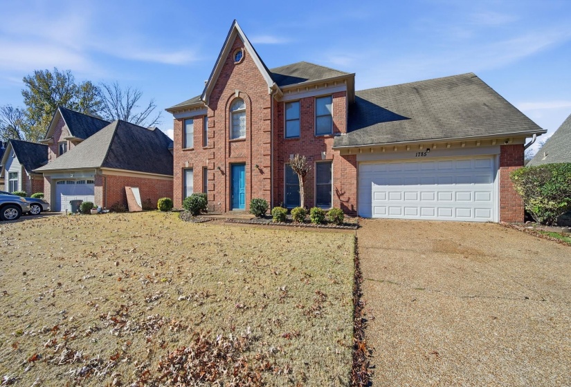 View of front of property featuring brick siding, concrete driveway, a front lawn, and an attached garage