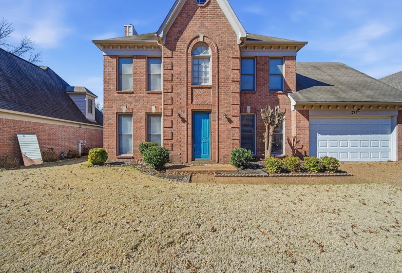 View of front of property featuring brick siding, a front lawn, and a shingled roof