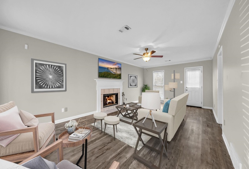 Living room featuring a fireplace, crown molding, wood finished floors, and ceiling fan