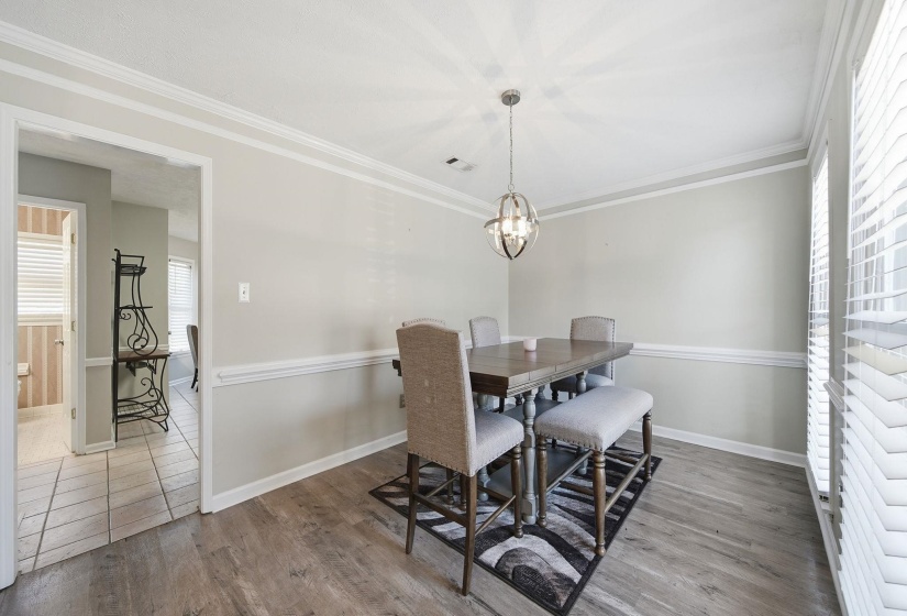 Dining room with ornamental molding and light wood-style floors