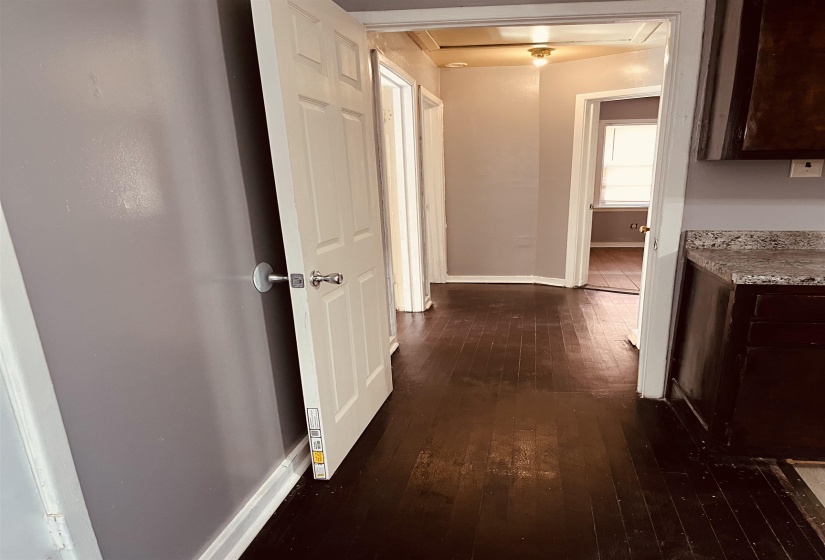 Hallway with baseboards and dark wood-style floors