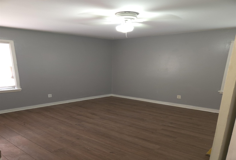 Empty room featuring dark wood-style floors and a ceiling fan