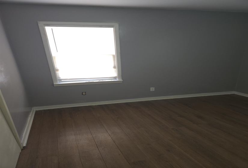 Unfurnished room with dark wood-type flooring and baseboards