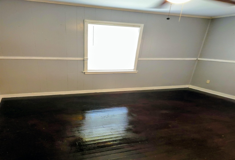 Unfurnished room featuring dark wood-style floors and a ceiling fan