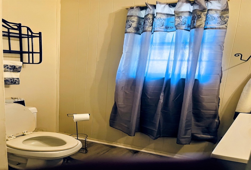 Bathroom featuring a shower with shower curtain and dark wood-style floors