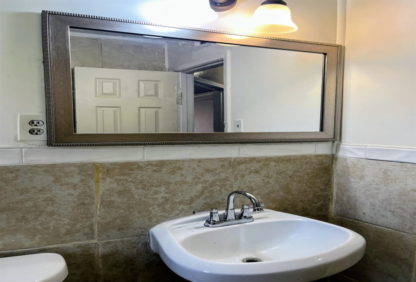 Bathroom with a sink and tile walls