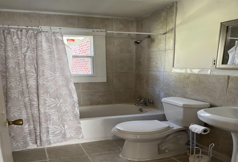 Full bathroom featuring shower / tub combo, tile walls, and tile patterned flooring